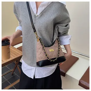 Dettaglio della trama trapuntata e catena dorata su una borsa hobo bicolore