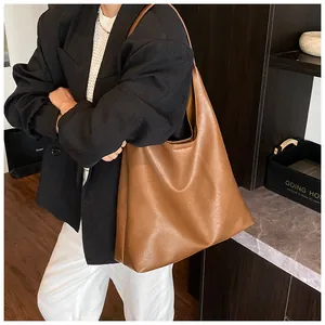 Detail of a large brown leather hobo bag worn over the shoulder for a chic commute style