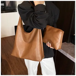 Detail of caramel faux leather tote bag and matching inner pouch on model outfit