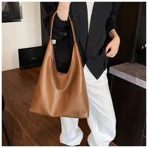 Brown leather large capacity tote bag shown on a model for casual office wear