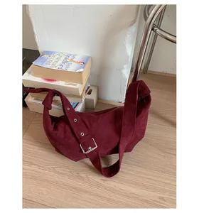 Détail du sac hobo en daim bordeaux avec large bandoulière réglable et boucle argent