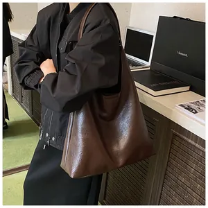 Close-up of the vintage textured dark brown leather tote bag on a model's shoulder