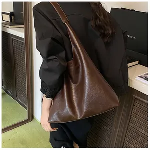 Dark brown large capacity tote bag worn over shoulder showing retro leather texture