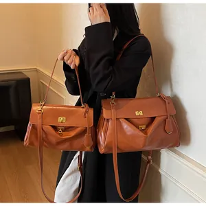Detail view of vintage brown leather tote bags in two sizes with gold hardware accents