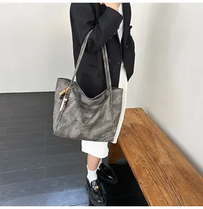 Detailed view of a vintage smoke gray oversized tote bag with bead charms on a model