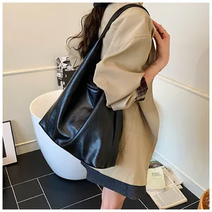 Lifestyle shot of large black textured PU leather tote bag in a minimalist interior setting