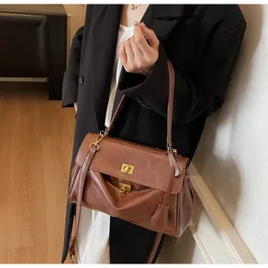 Detail of vintage brown tote bag with gold metal twist lock and leather texture