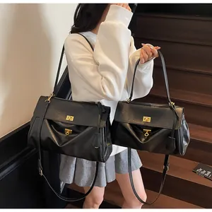 Size comparison of large and small black leather tote bags with gold hardware