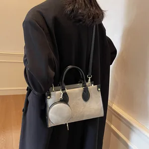 Two-tone tote bag in grey and black with mini round pouch and crossbody strap on model