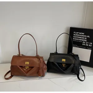 Detail view of brown and black leather tote bags with gold twist locks and long shoulder straps