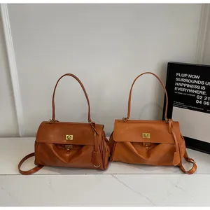 Detail of tan faux leather tote bags with gold twist locks on marble surface