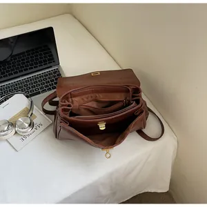 Top view of brown leather tote bag interior compartments with laptop and office accessories