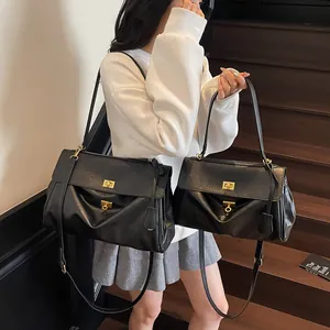 Black leather tote bag set in large and small sizes with gold hardware on wooden stairs