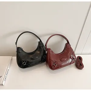 Detailed macro view of vintage semi-circle hobo bags in black and burgundy textured leather