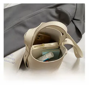 Interior view of beige bucket bag showing capacity for phone, wallet and cosmetics