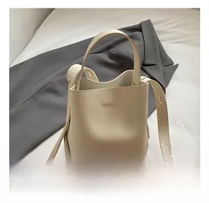 Detail of lychee pattern leather bucket bag with top handle and fine stitching accents