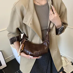 Dark brown crescent leather shoulder bag with wooden bead fringe and knotted strap