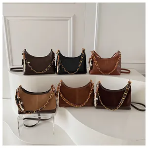 Détails de sacs demi-lune en plusieurs textures avec chaînes dorées et glands perlés