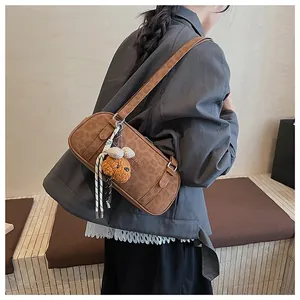 Detail of brown leopard embossed shoulder bag with cute plush bear charm on its side strap