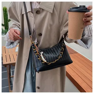 Détail du sac hobo tissé noir avec chaîne dorée et breloque en perles de bois