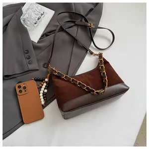 Détail du sac seau marron rétro avec texture en daim et breloque chaîne de perles