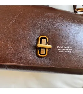 Primer plano del cierre de metal dorado y textura de cuero marrón del bolso chic