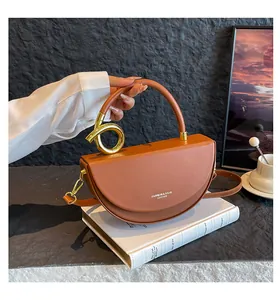 Detailed shot of brown saddle bag with gold metal rings on a white book display