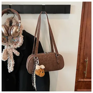 Brown bowling shoulder bag with leopard pattern embossing and a cute teddy bear charm