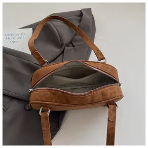 Close-up of brown suede bag interior featuring gray lining and zipper pocket detail