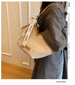 Détail du sac cabas en toile avec garniture en cuir marron et design d'ouverture en V