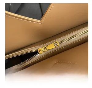 Détail du zip doré fluide et de la découpe en V sur le sac fourre-tout en cuir tan