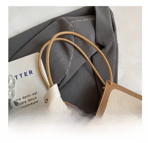 Gros plan sur le sac en toile beige avec lanières en cuir brun et détail noué