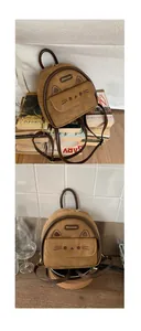 Détail d'un mini sac à dos en daim marron avec broderie chat et poche frontale magnétique