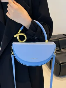 Light blue crescent saddle bag with gold metal knot and adjustable shoulder strap