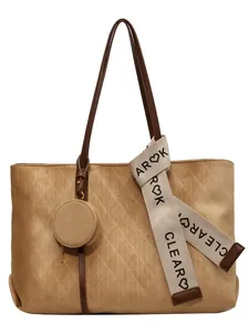 Brown faux suede tote bag with diamond lattice pattern and silk scarf on white background