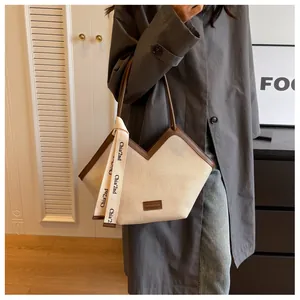 Détail du sac cabas en toile avec garniture en cuir marron et foulard décoratif