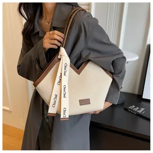 Détail du sac cabas en toile avec garniture en cuir en V et ruban décoratif