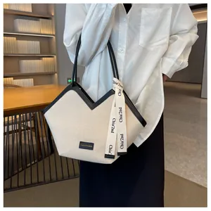 Détail du sac cabas en toile avec bordure en cuir noir et détail de foulard en soie décoratif