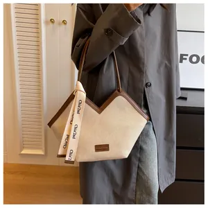 Détail du sac fourre-tout en toile en V avec bordure en cuir marron et foulard décoratif