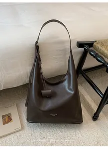 Detail of dark brown leather Hobo bag with adjustable strap and embossed white lettering