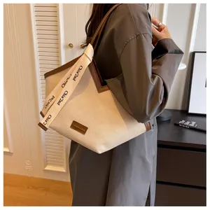 Détail du sac cabas en toile beige avec bordure en cuir marron et sangle décorative