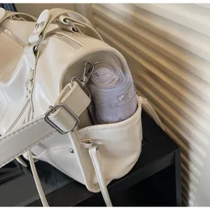 Detailed side view of off-white chic tote bag with utility pocket and silver metal hardware
