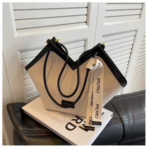 Détail du sac fourre-tout en toile avec bordure en cuir noir et ouverture en forme de V