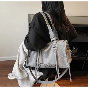 Dettaglio borsa tote grigia vintage con rivetti, tracolla e fibbie in metallo lucido
