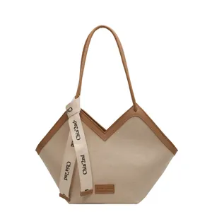 Grand sac cabas en toile beige avec poignées en cuir marron et ruban de soie élégant