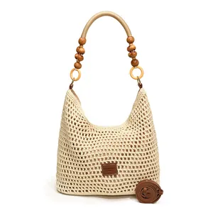 Hollow knit tote bag in cream white with wooden beads and a brown leather logo tag
