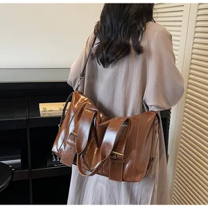Vista posteriore di una modella con una grande borsa tote marrone in pelle sintetica