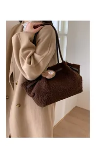 Close-up of brown faux shearling tote bag featuring a cute cartoon bear patch detail
