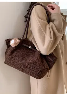 Detailed texture of brown plush lamb wool shoulder bag with cute bear charm and leather strap