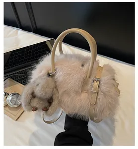 Close-up of soft faux fur handbag in pale pink with matching cute bunny plush charm